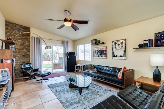 living area with tile patterned flooring, a ceiling fan, and vaulted ceiling