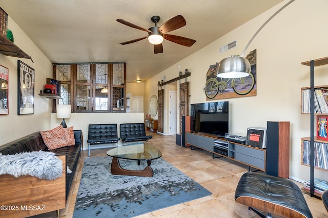 living room with a barn door, visible vents, and ceiling fan