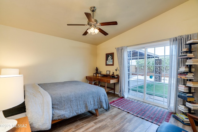 bedroom featuring lofted ceiling, wood finished floors, a ceiling fan, and access to outside