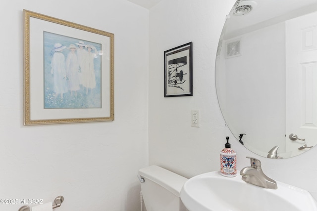 bathroom with visible vents, toilet, and a sink