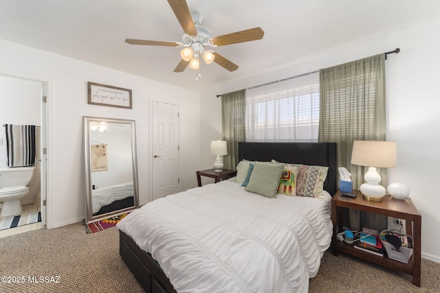 carpeted bedroom with a ceiling fan, baseboards, and ensuite bathroom