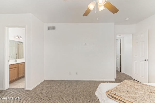 unfurnished bedroom featuring baseboards, light colored carpet, visible vents, and connected bathroom