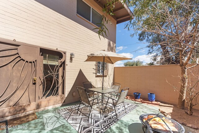 view of patio featuring outdoor dining space and fence