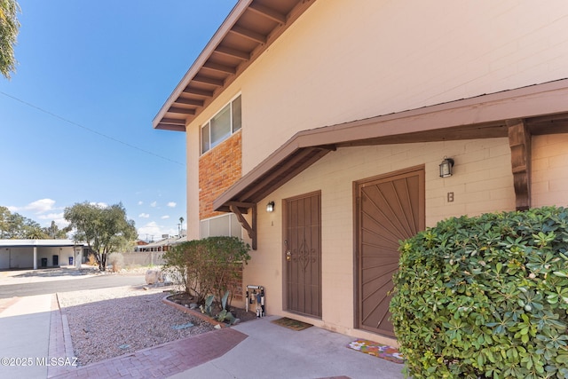 doorway to property with brick siding and a patio