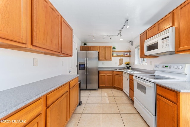 kitchen with white appliances, light tile patterned floors, open shelves, a sink, and light countertops