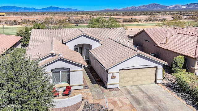 view of front of house featuring a mountain view, a tile roof, and driveway