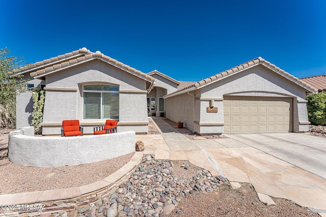 view of front of property featuring stucco siding, a garage, concrete driveway, and a tile roof