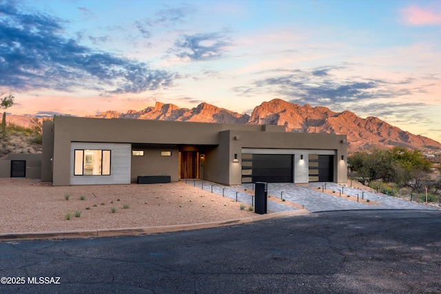 southwest-style home with a mountain view, stucco siding, and an attached garage