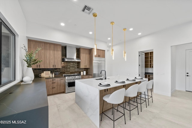 kitchen with visible vents, backsplash, premium appliances, modern cabinets, and wall chimney exhaust hood