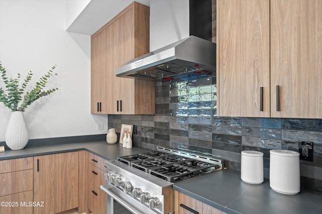 kitchen featuring dark countertops, tasteful backsplash, high end stainless steel range, and wall chimney range hood