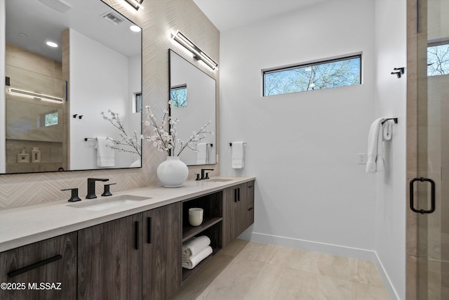 full bathroom featuring a sink, visible vents, backsplash, and a shower stall