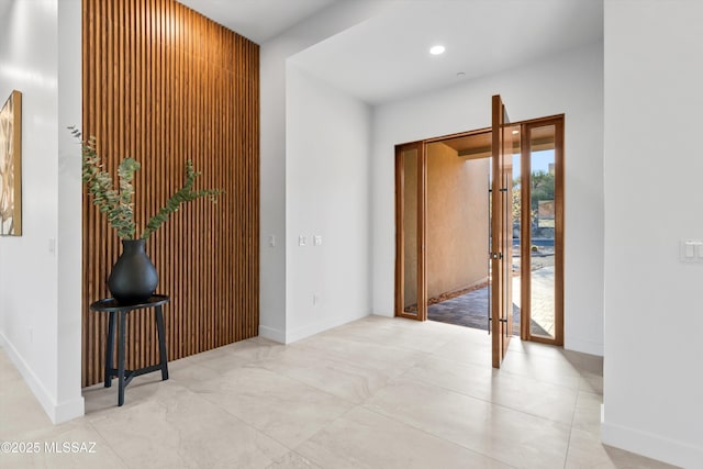 hall with recessed lighting and baseboards