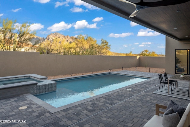 view of swimming pool featuring a patio, a fenced backyard, a mountain view, a fenced in pool, and an in ground hot tub