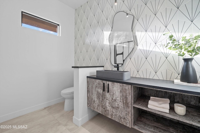 bathroom with tile patterned floors, baseboards, toilet, and vanity