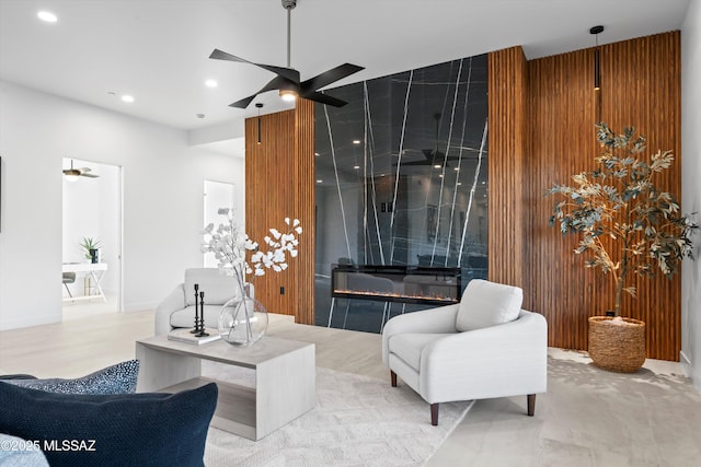 living area featuring recessed lighting, ceiling fan, and a high end fireplace