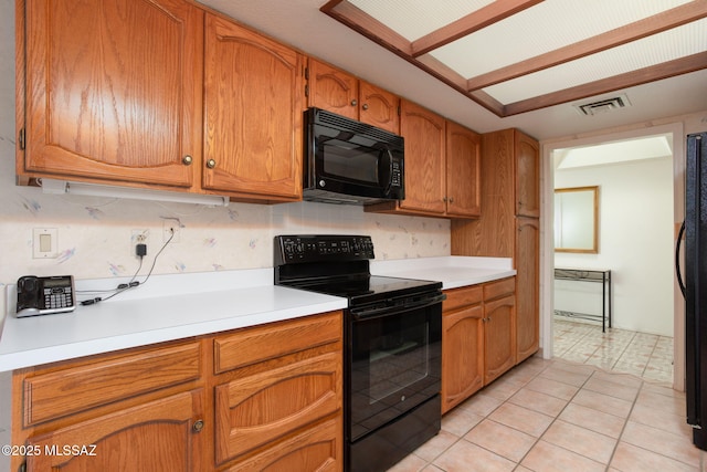 kitchen featuring visible vents, black appliances, light countertops, light tile patterned floors, and decorative backsplash