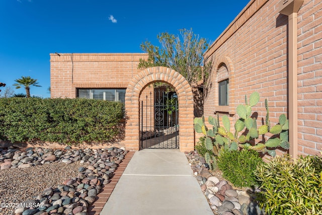 property entrance with a gate and brick siding