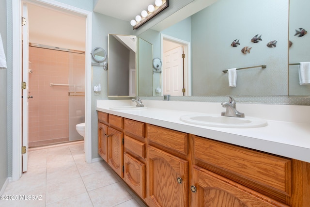 full bath with tile patterned flooring, double vanity, toilet, and a sink