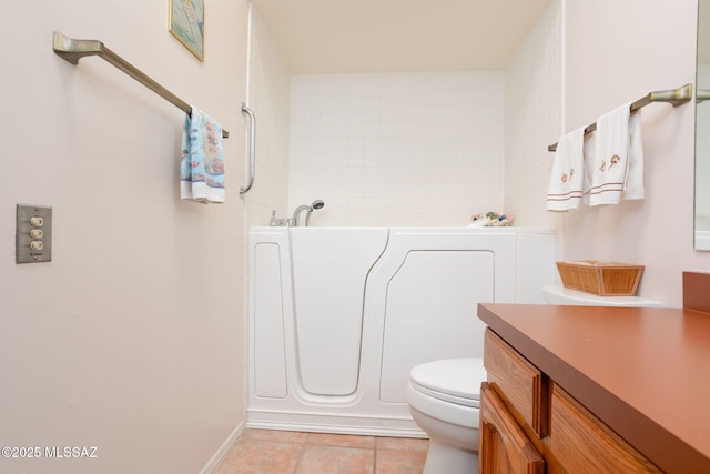 bathroom featuring vanity, tile patterned floors, a bath, and toilet