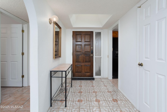 entryway featuring light tile patterned floors and a textured ceiling