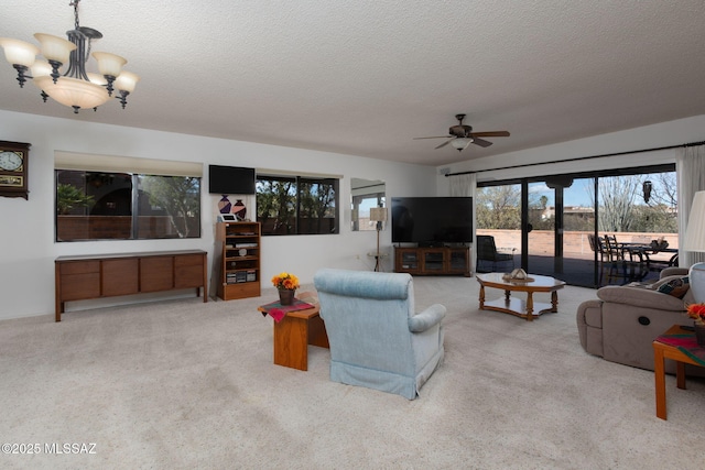 living room with ceiling fan with notable chandelier, carpet floors, and a textured ceiling