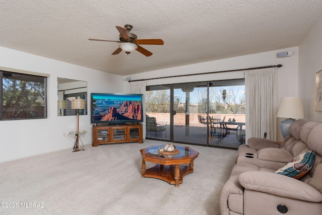 living room featuring carpet flooring, a ceiling fan, and a textured ceiling