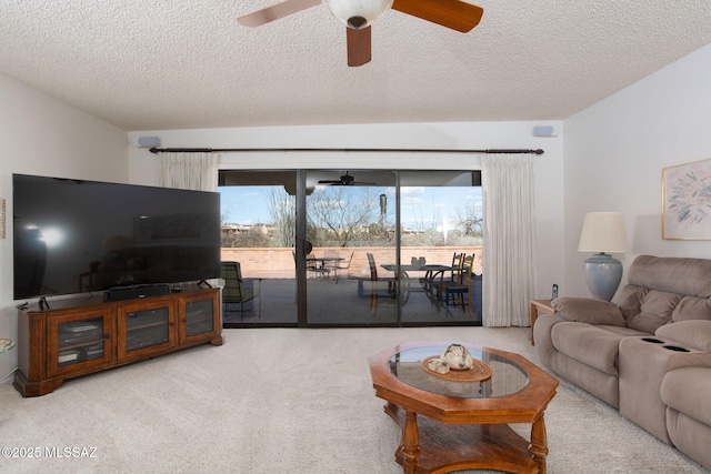 living area with carpet flooring, a textured ceiling, and ceiling fan