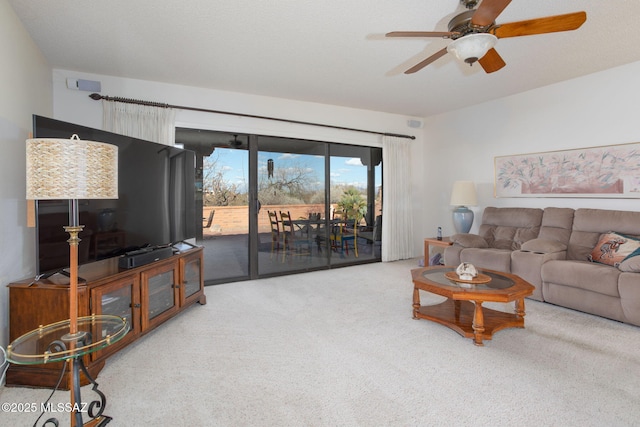 living room featuring a ceiling fan and carpet