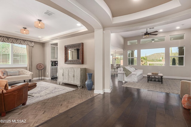 living area with visible vents, baseboards, a tray ceiling, recessed lighting, and wood-type flooring