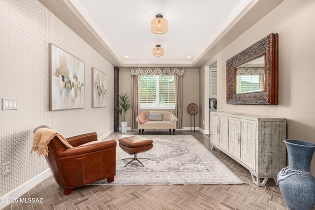 living area with wallpapered walls, a raised ceiling, baseboards, and ornamental molding