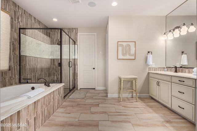 bathroom with vanity, visible vents, baseboards, a shower stall, and a garden tub