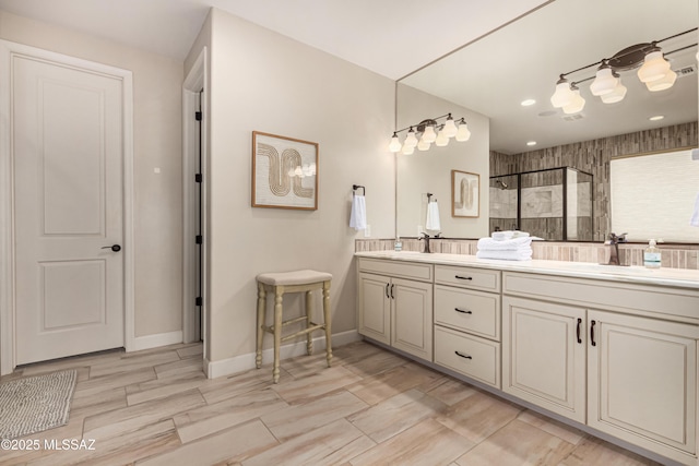 full bath with a shower stall, double vanity, baseboards, and a sink