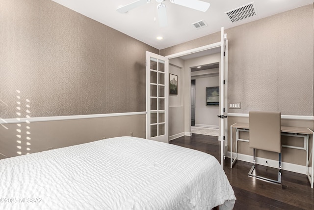 bedroom with wallpapered walls, wood finished floors, visible vents, and ceiling fan