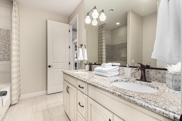 full bathroom with double vanity, baseboards, visible vents, and a sink