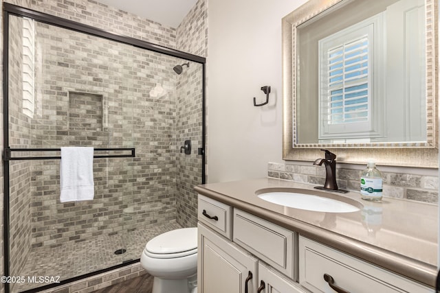 full bathroom with vanity, a shower stall, and toilet