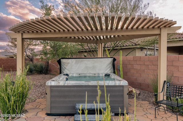 patio terrace at dusk with a hot tub and fence