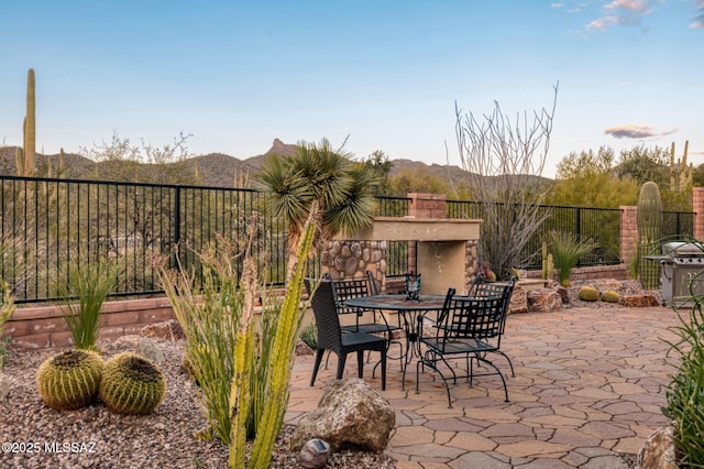 view of patio / terrace featuring a mountain view, outdoor dining space, and fence