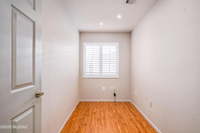unfurnished room featuring recessed lighting, light wood-style floors, and baseboards