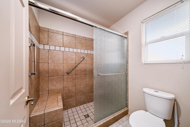 bathroom featuring toilet and a stall shower