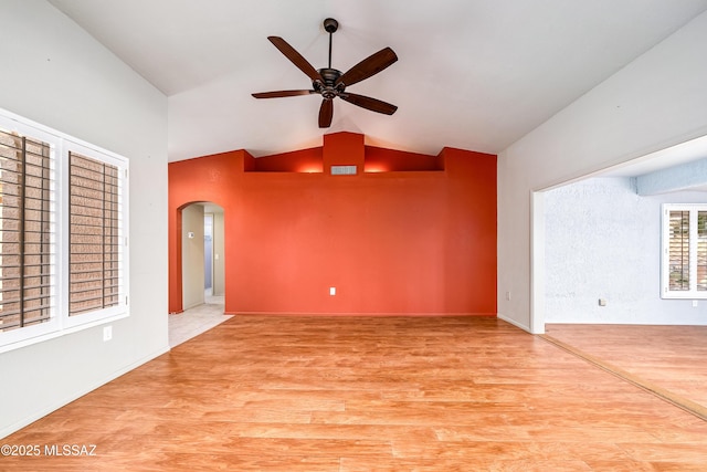 unfurnished living room with arched walkways, light wood-style flooring, visible vents, and ceiling fan