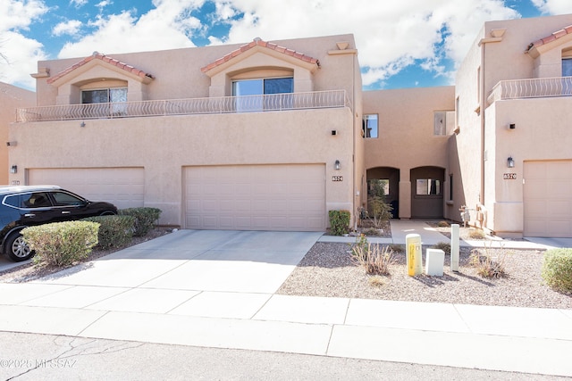 view of front facade featuring stucco siding, concrete driveway, and a garage