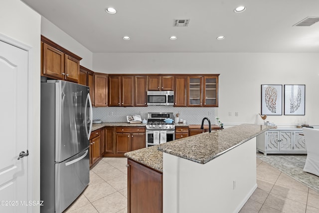 kitchen featuring light stone counters, visible vents, appliances with stainless steel finishes, and light tile patterned flooring