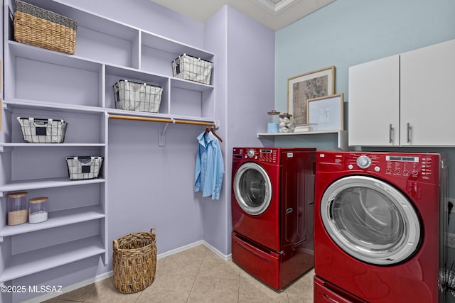 clothes washing area with cabinet space, washing machine and dryer, baseboards, and tile patterned floors