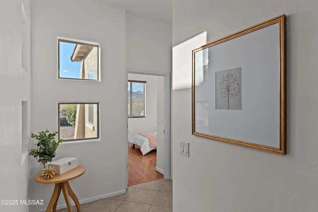 hall with light tile patterned floors and baseboards