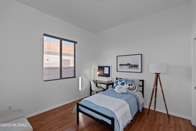 bedroom with baseboards and wood finished floors