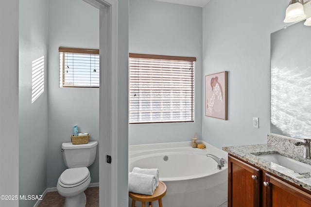 bathroom featuring tile patterned floors, a garden tub, vanity, and toilet