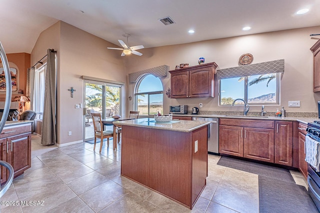 kitchen featuring visible vents, a kitchen island, ceiling fan, a sink, and stainless steel dishwasher