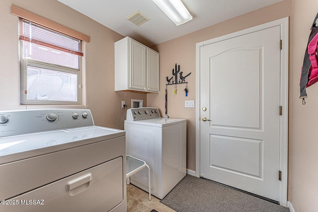 clothes washing area with baseboards, visible vents, cabinet space, and independent washer and dryer