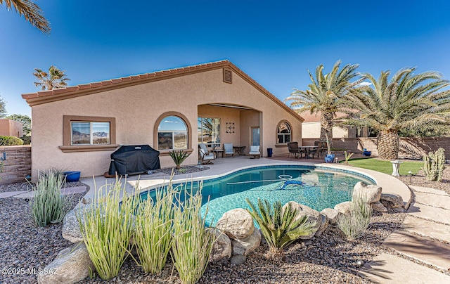 view of swimming pool with a fenced in pool, a grill, and a patio