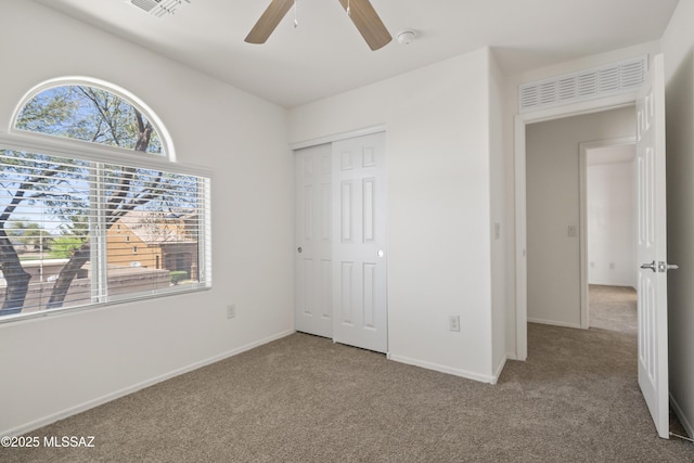 unfurnished bedroom with a closet, carpet flooring, baseboards, visible vents, and ceiling fan
